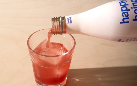 A glass being filled with Happy being tea