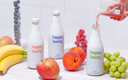 Fruits arranged around bottle of happy being tea