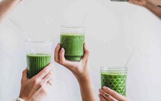 Primal harvest greens being held up by multiple hands